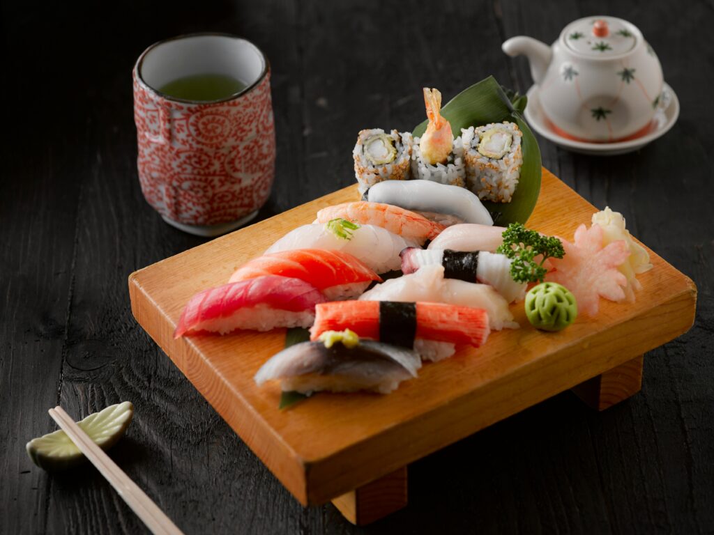 Elegant display of sushi with green tea on a wooden board, capturing authentic Japanese cuisine.
