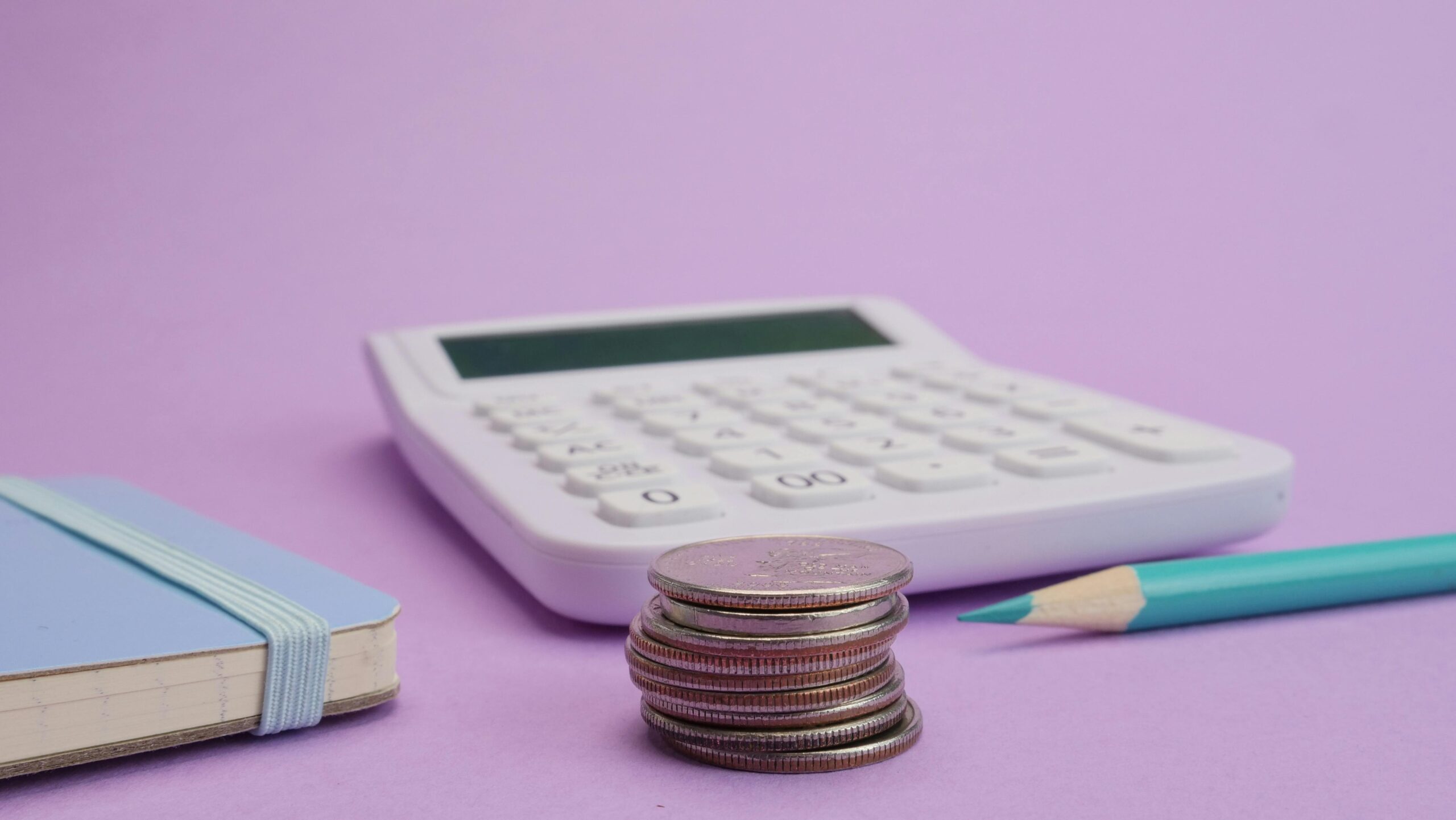 Calculator, Japanese yen coins, and stationery symbolizing budgeting and cost of living in Japan for immigrants over 40.