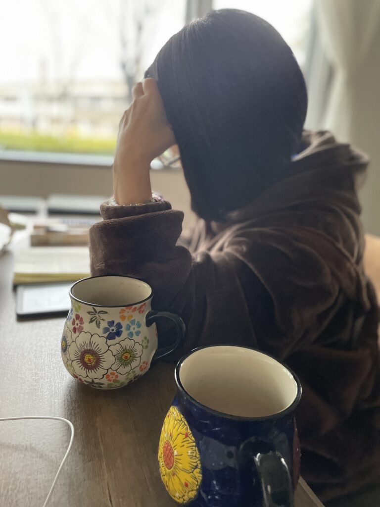 Aya studying for the Takken Real Estate exam in a cafe with coffee mugs.