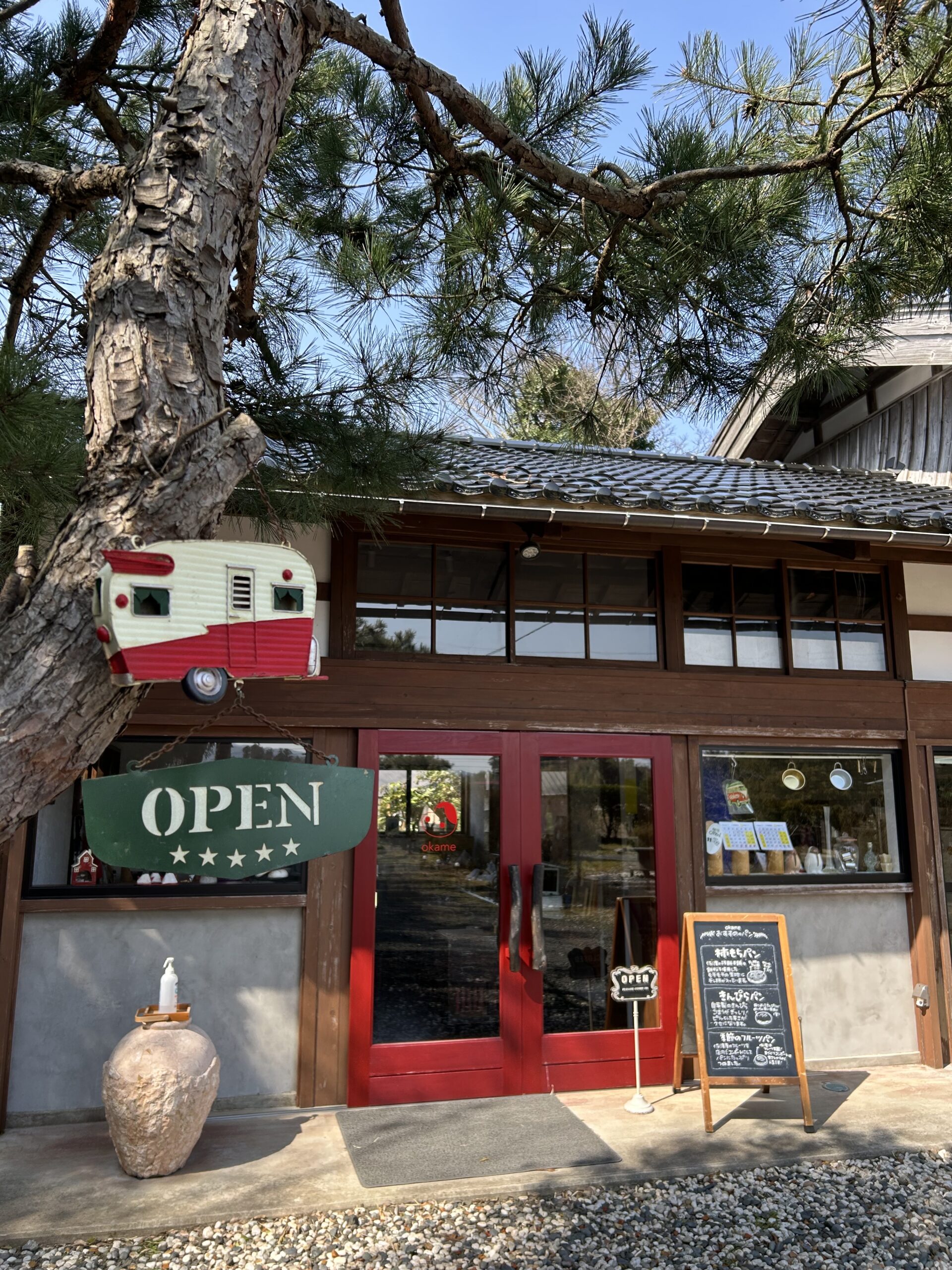 おかめパン — red doors, old pine tree, traditional tiled roof on Sado Island