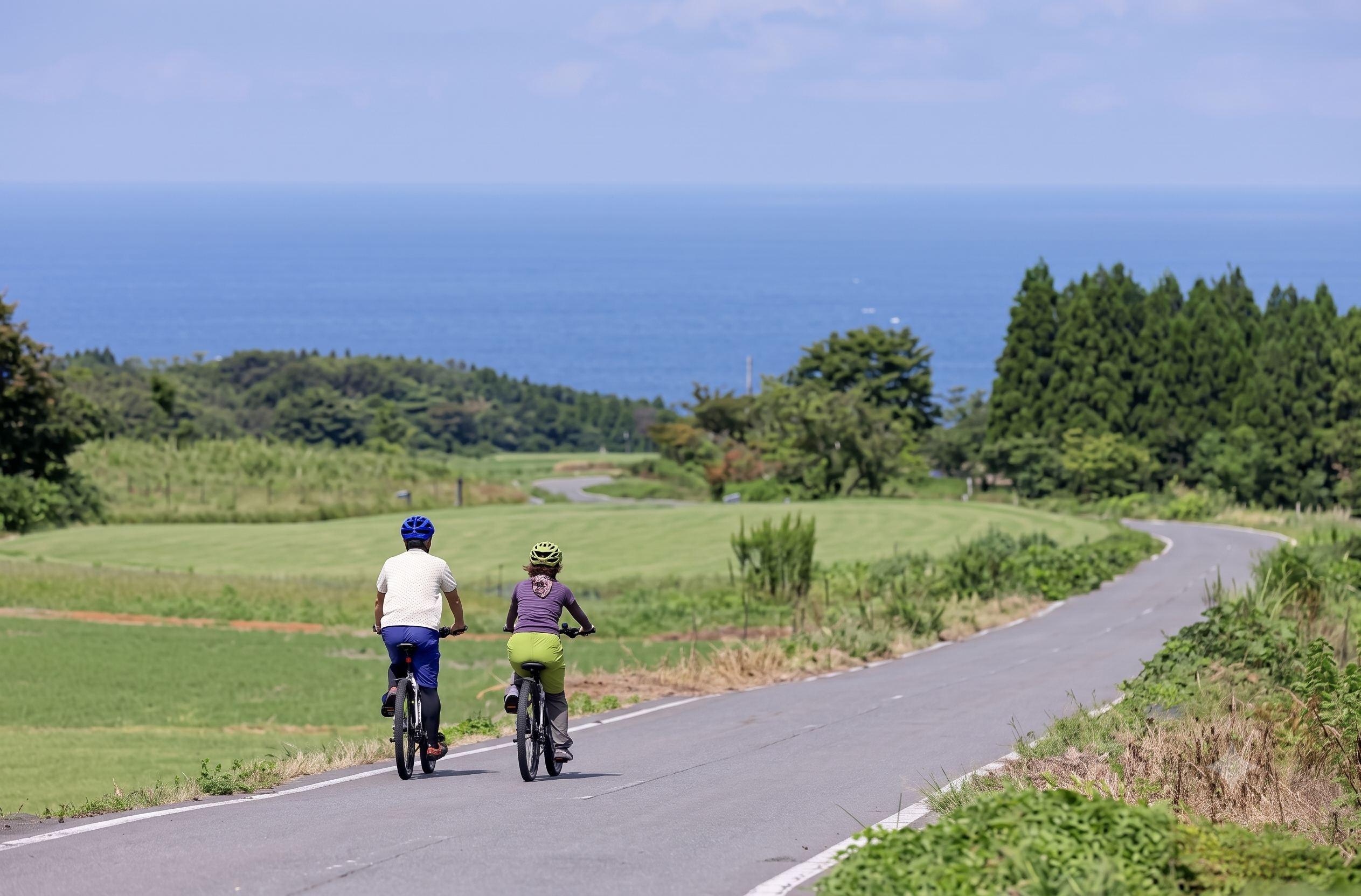 Cyclists riding along the Sado Island coastline near Niigata